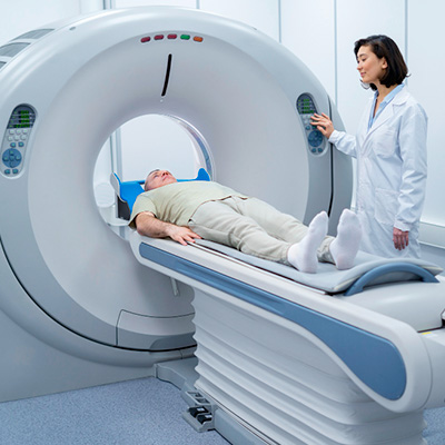 Une femme médecin effectue un scanner à son patient qui est allongé dans une salle d’hôpital blanche