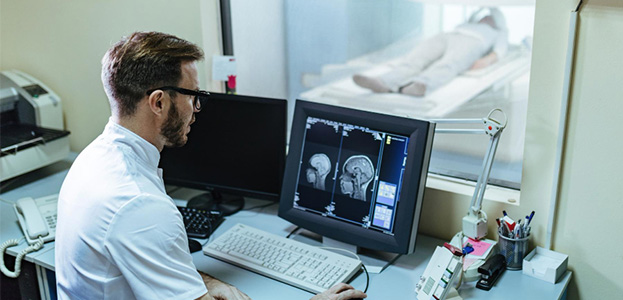 Un homme médecin consulte une radiologie sur son ordinateur